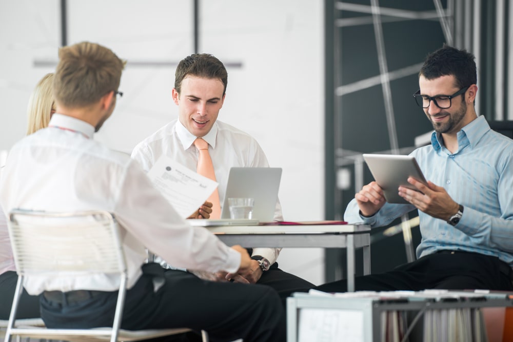 A group of corporate people working by the office table-min